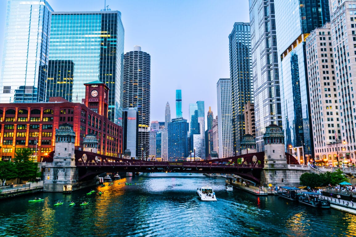 Illuminated Chicago Riverwalk and Skyscrapers at dusk.